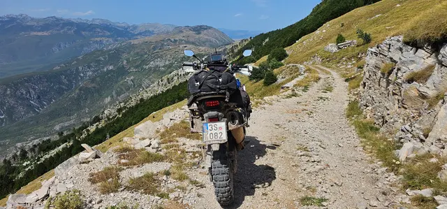 Na motorce v horách, prašná cesta.