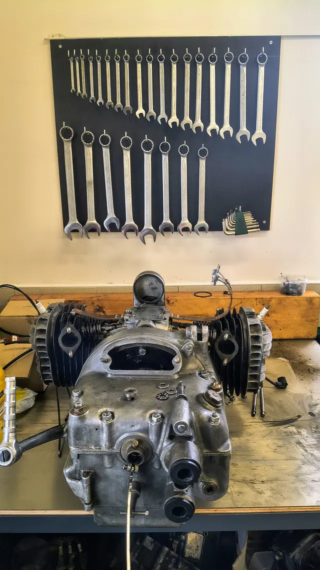 Motor na dílenském stole a sada klíčů v motoservisu