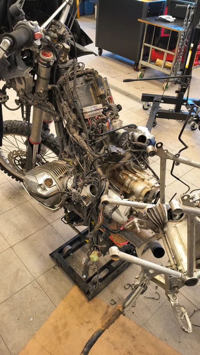 Rozebraný motocykl na zvedáku v motoservisu