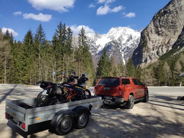 Přeprava motorek na místo výpravy: pick-up s přívěsem v horách.