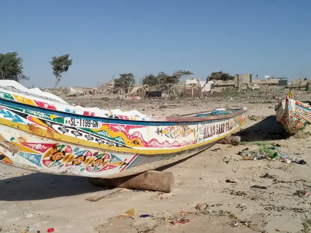 Barevná rybářská loď na písečném břehu v Senegalu.