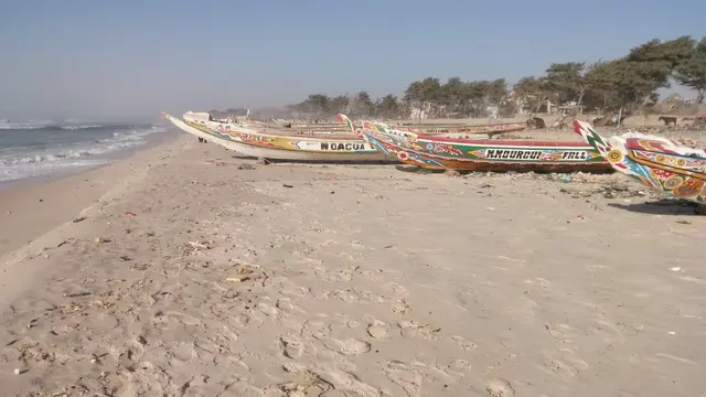 Barevné rybářské lodě na písečné pláži v Senegalu