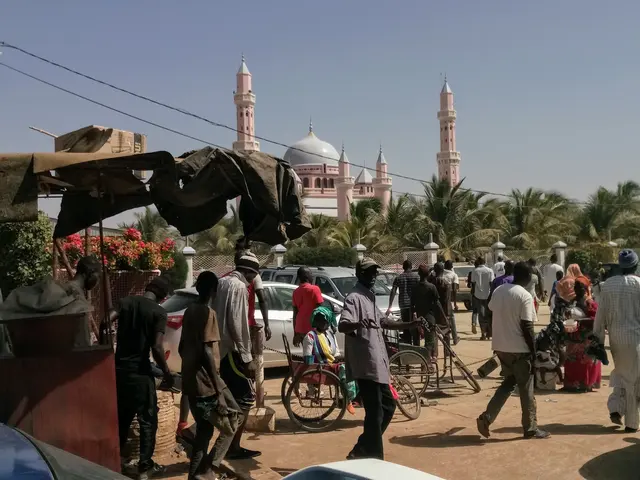 Rušná ulice v Senegalu s lidmi a mešitou v pozadí
